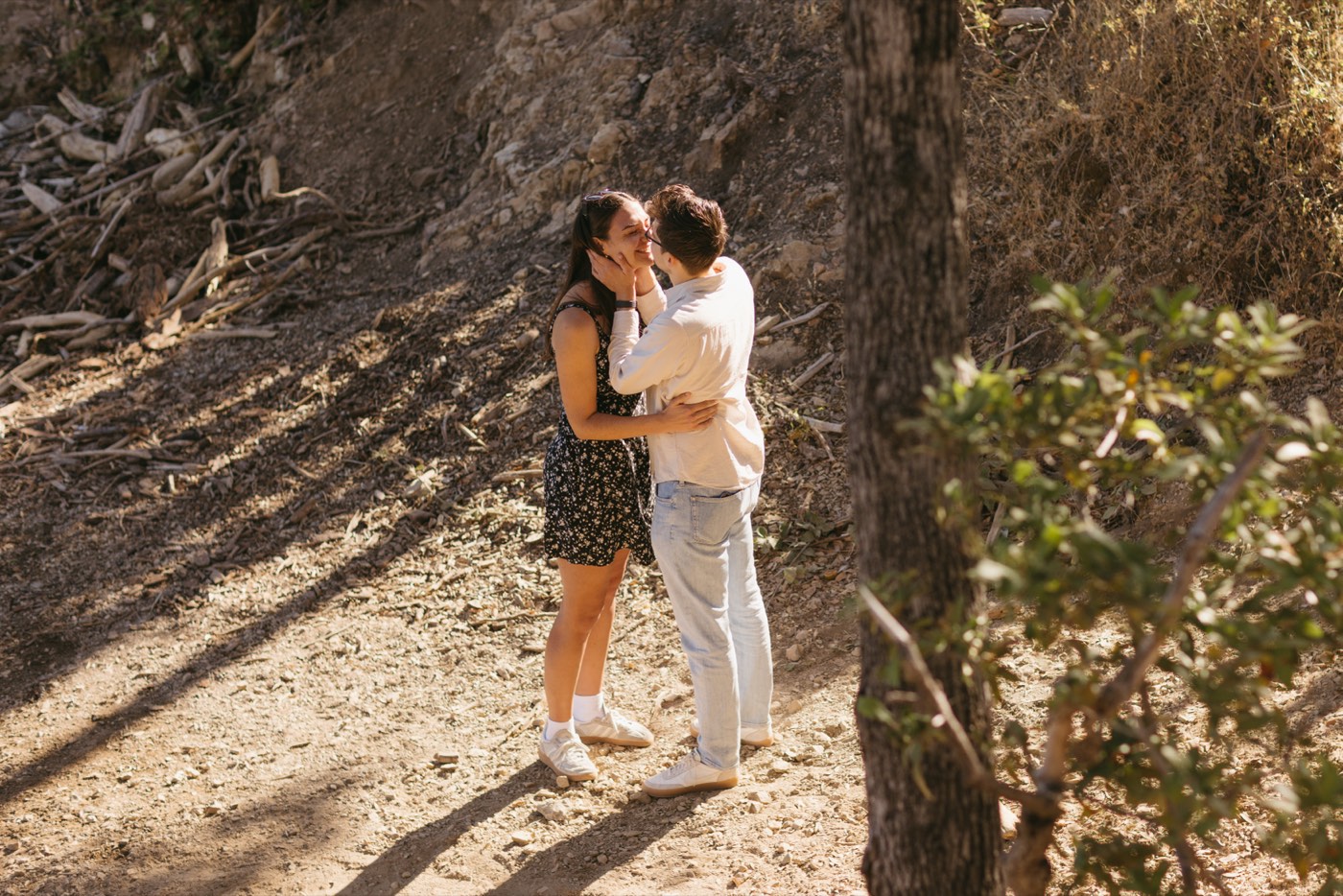 Andrea and Alex kissing on the trail in the afternoon light